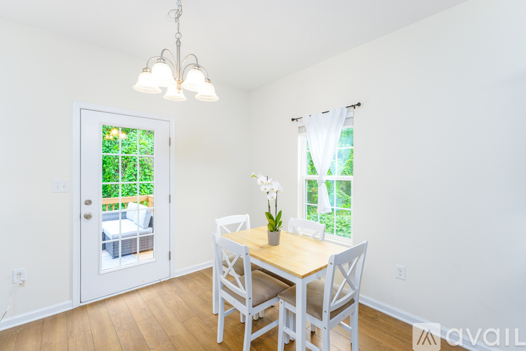 A dining room with a table and chairs and a chandelier.
