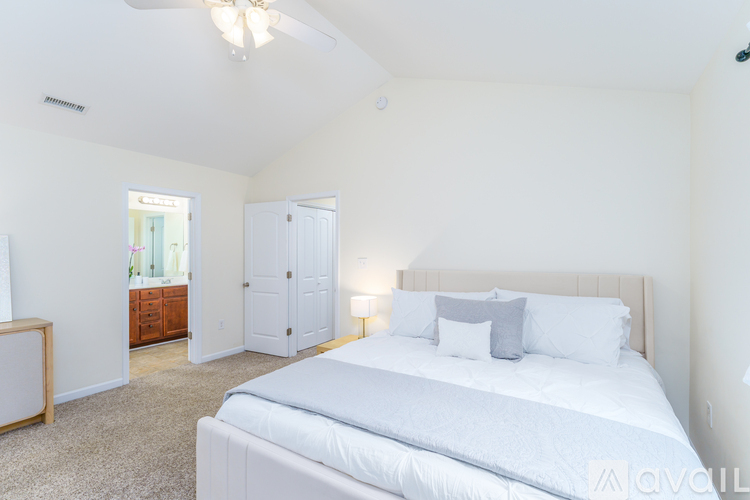 A bedroom with a large bed and a ceiling fan.