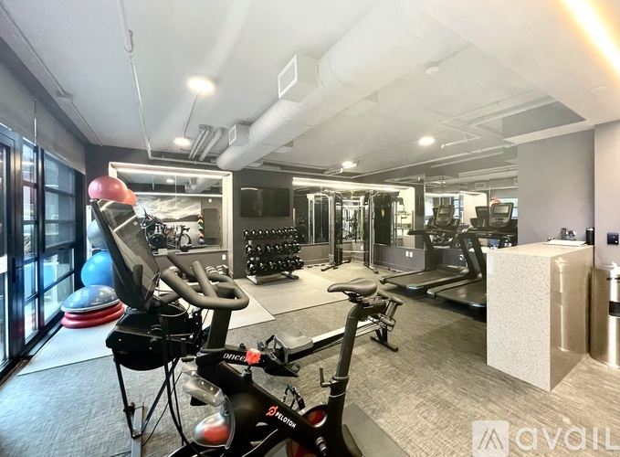 A gym with a variety of equipment including treadmills, stationary bikes, and weight machines.