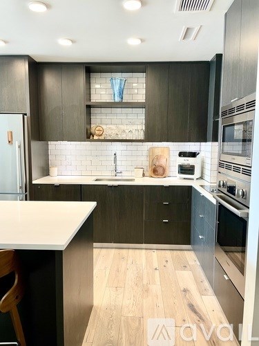 A modern kitchen with dark wood cabinets and a white countertop.