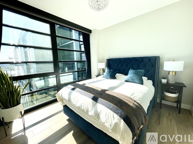 A bedroom with a large bed and a window overlooking a cityscape.
