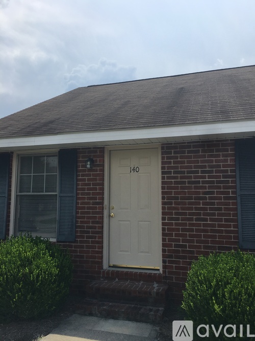 A house with a white door and a brick wall.