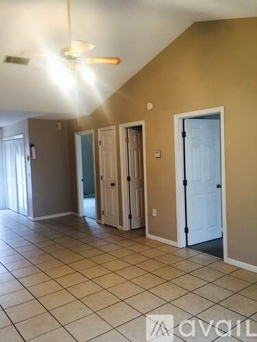A room with a ceiling fan and tile flooring.