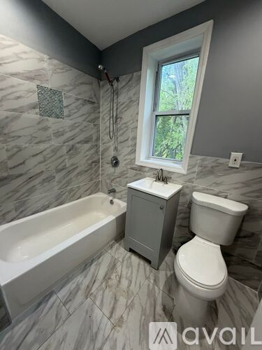 A bathroom with a tub, toilet, and sink.