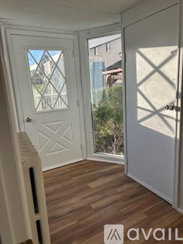 A white door with a glass window and a wooden floor.