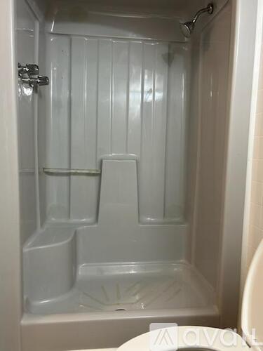 A white bathroom with a shower stall and a toilet.