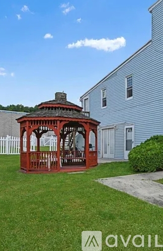 A gazebo is in front of a house.