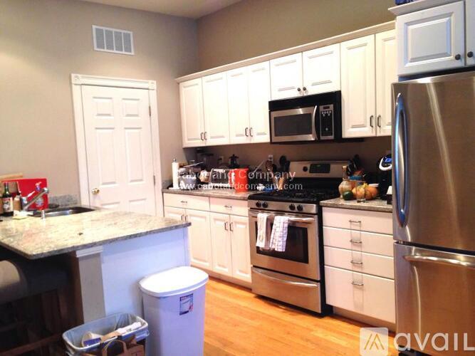 A kitchen with white cabinets and a black countertop.