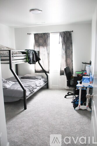 A bedroom with a bunk bed and a desk with a chair.