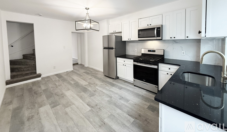 A kitchen with black countertops and white cabinets.