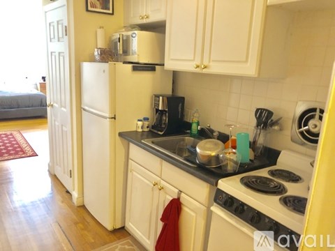 A kitchen with a white fridge and a stove top oven.