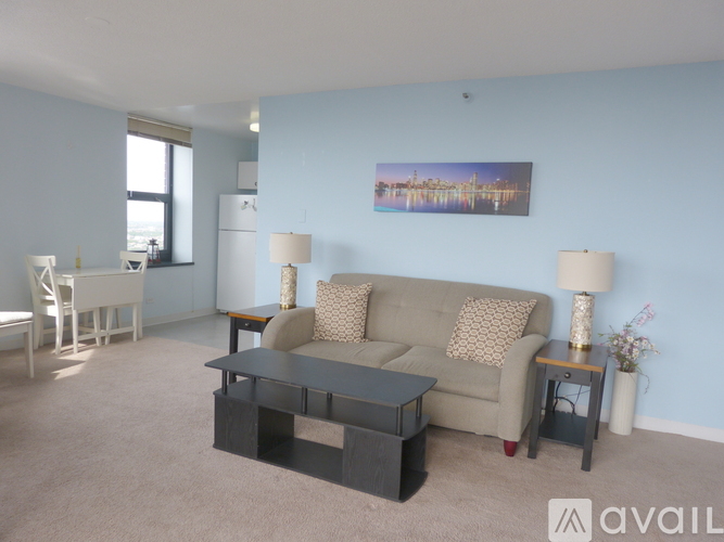 A living room with a couch, two lamps, and a painting on the wall.