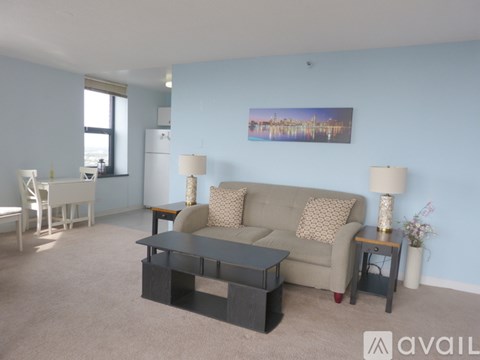 A living room with a couch, two lamps, and a painting on the wall.