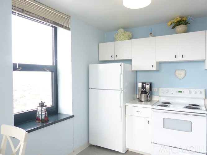 A white refrigerator and oven in a kitchen with blue walls.