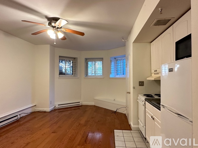 A kitchen with white cabinets and a wooden floor.