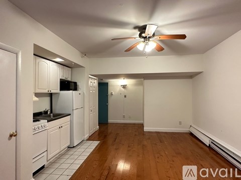 A kitchen with white cabinets and a ceiling fan.