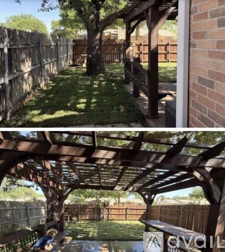 A backyard with a wooden pergola and a tree.