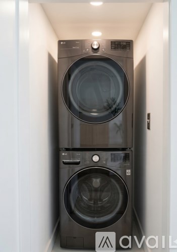 A stack of two front loading washing machines in a narrow space.
