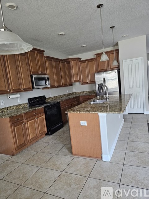 A kitchen with brown cabinets and a granite countertop.