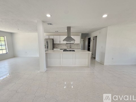 A spacious kitchen with white cabinets and a central island.