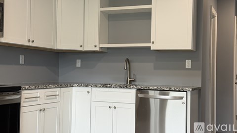 A kitchen with white cabinets and a granite countertop.