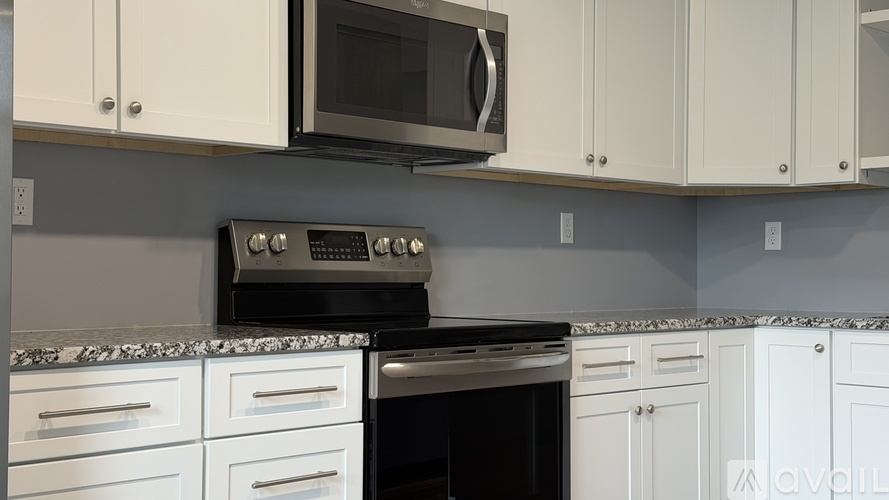 A kitchen with white cabinets and a black oven.