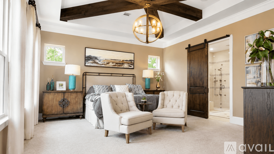 A living room with a ceiling fan, two chairs, a sofa, and a side table with a lamp.