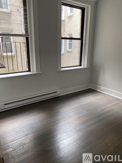A room with a window and wooden flooring.