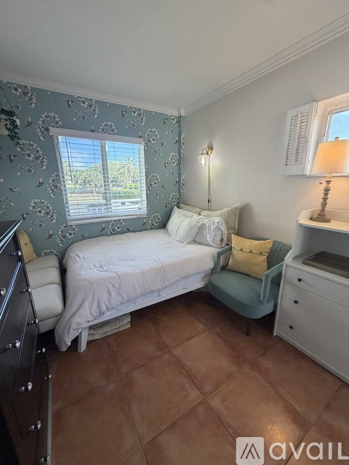 A bedroom with a bed, dresser, and chair.