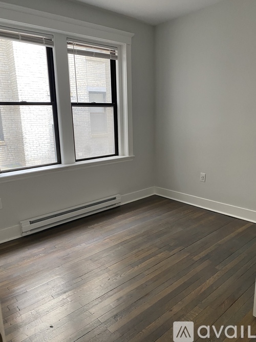 A room with a window and a wooden floor.