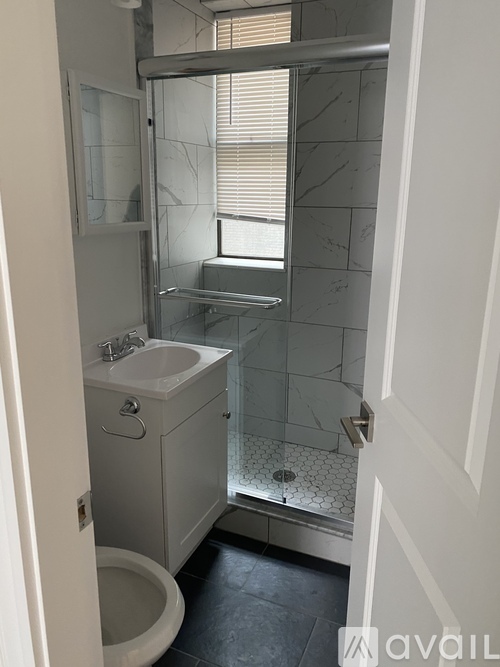 A bathroom with a toilet, sink, and shower.