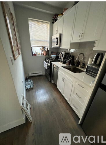 A kitchen with white cabinets and a window.