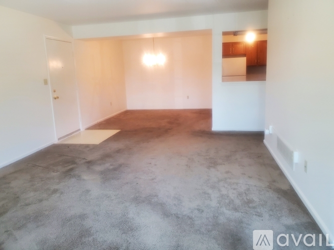 A large empty room with a concrete floor and white walls.