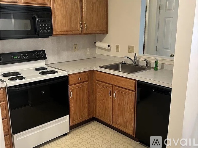 A kitchen with a black microwave above a white stove.