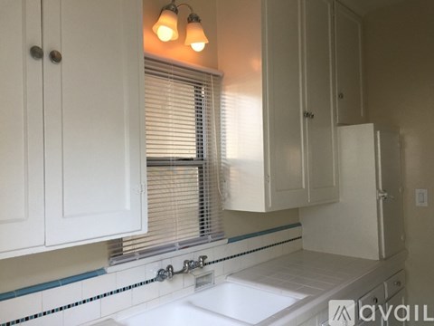 A white kitchen with a sink and cabinets.