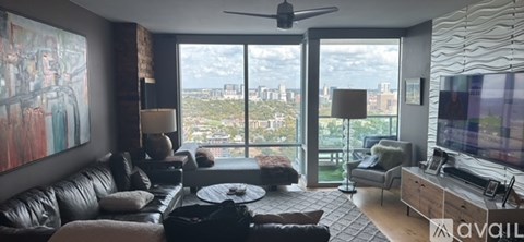 A living room with a large window overlooking a cityscape.