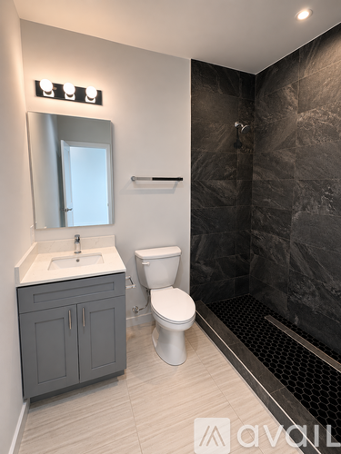 A bathroom with a toilet, sink, and shower.