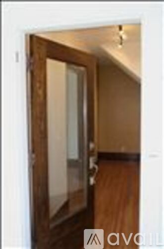 A wooden door with a glass panel is in the foreground.