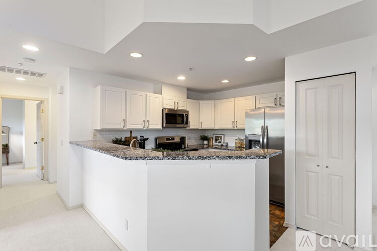 A modern kitchen with a granite countertop and stainless steel appliances.