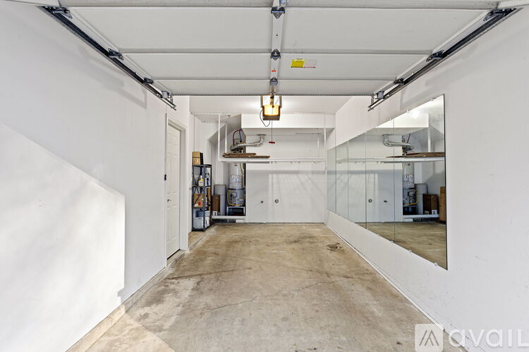 A large, empty industrial space with white walls and a concrete floor.