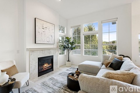 A living room with a fireplace and a painting on the wall.
