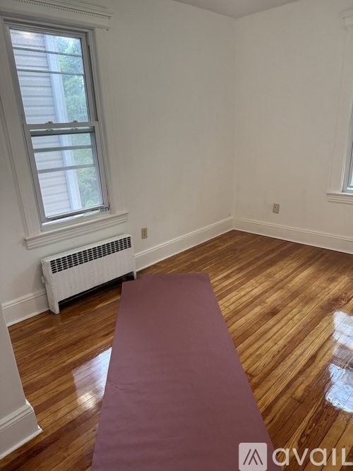 A room with a window and a radiator on the wall.