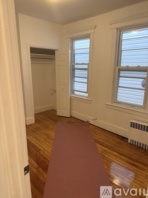 A room with a red yoga mat on the floor.