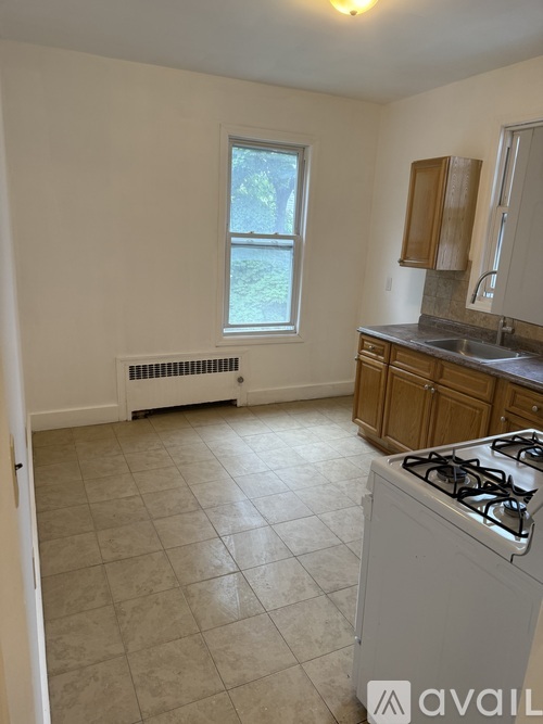 A kitchen with a white stove and a window with a view of trees outside.