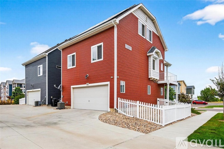 A red house with a white fence in front.
