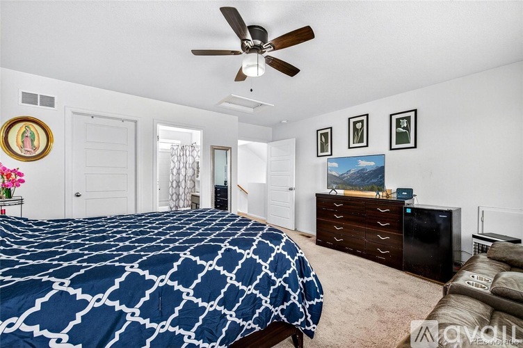 A bedroom with a large bed and a ceiling fan.