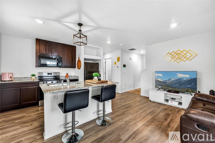 A modern kitchen with dark wood cabinets and a white island.