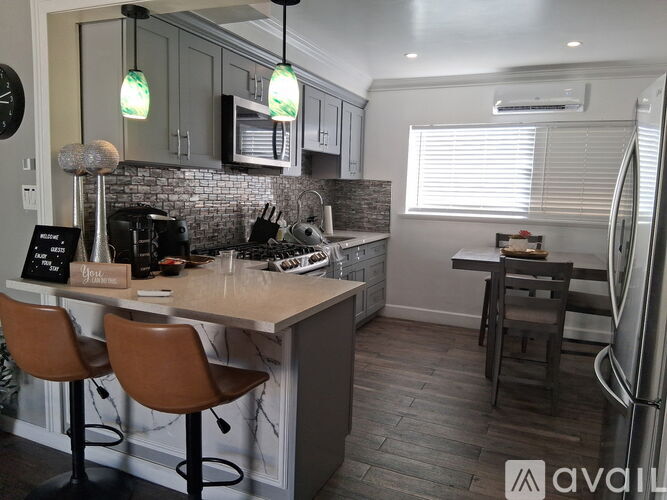 A kitchen with a marble countertop and a refrigerator.