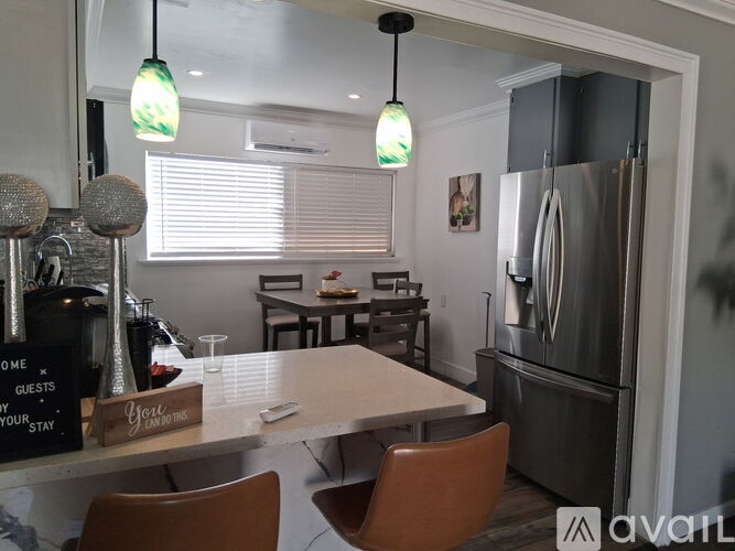 A kitchen with a table and chairs and a sign that says "home guests your stay".