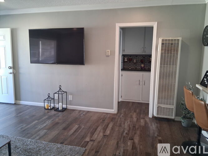 A living room with a flat screen TV mounted on the wall.
